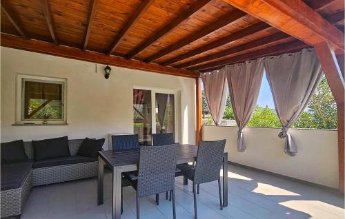 a patio with a table and chairs and a couch at Amazing Apartment In Baska With Swimming Pool in Draga Bašćanska