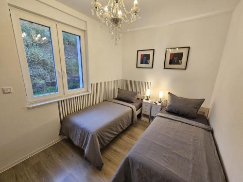 two beds in a room with a chandelier at Altenbeken-Ferienwohnung 2 in Altenbeken
