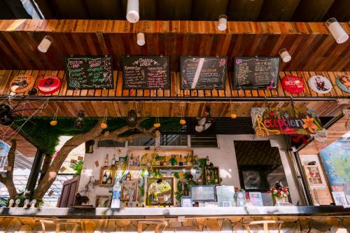 a restaurant with a counter with signs on it at SECRET GARDEN Hostel - WANDERNEST Cat Ba in Cat Ba