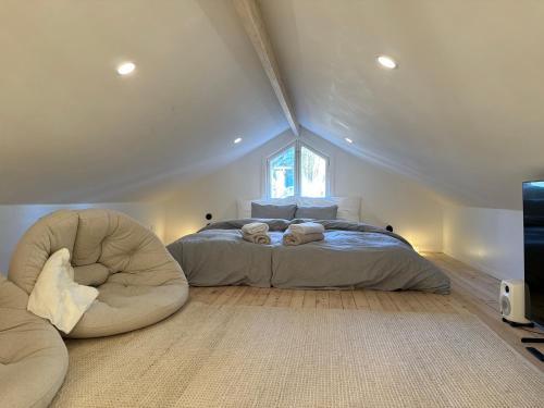 ロヴァニエミにあるNEW - Luxury Loftのベッドルーム1室(ベッド1台、屋根裏部屋の椅子付)