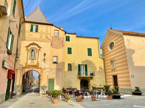 a group of buildings with tables and chairs in a street at La tua Vacanza al Mare in Borghetto Santo Spirito