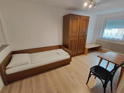 a small bedroom with a bed and a table at Ferienwohnung Schwartz in Neusiedl am Steinfelde