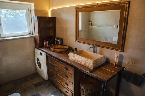 a bathroom with a sink and a washing machine at Guest House dei Cavalli in Lobbi