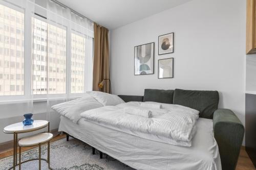 a bed in a room with a green couch at LAM Discovery AC - Balcony in Nivy
