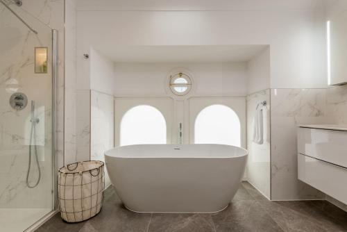 a white bathroom with a tub and a shower at Skye Sands - St Marys Gardens - St Andrews in St. Andrews
