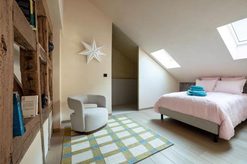 a bedroom with a bed and a chair at The incredible Alsatian house of the 21st century in Hangenbieten