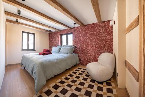 a bedroom with a bed and a chair at The incredible Alsatian house of the 21st century in Hangenbieten