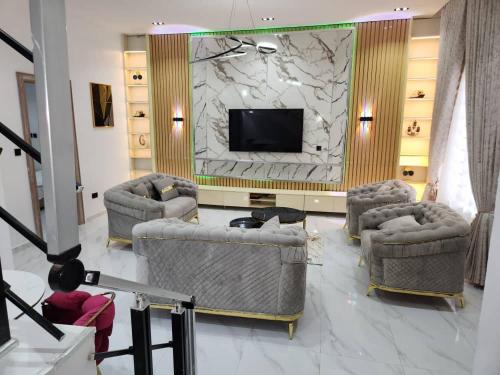 Una sala de estar con dos sillas y un televisor. en LPMD Apartment, en Ikuata