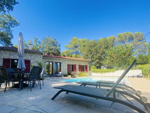 un patio con mesa, sombrilla y piscina en Holiday Home Les Pierres Fleuries by Interhome, en Trans-en-Provence