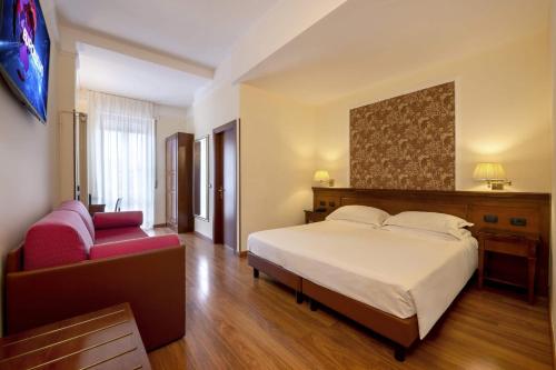 a bedroom with a large bed and a red couch at Lancaster Hotel in Milan