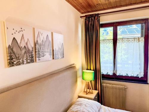 a bedroom with a bed and a lamp and a window at Apartment Marmolada-12 by Interhome in Alba di Canazei