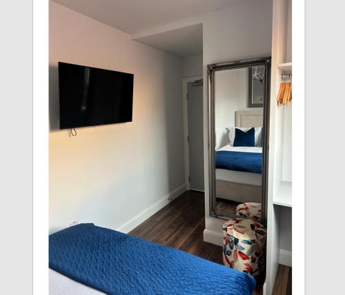 a bedroom with a mirror and a bed and a tv at Auld Shebeen in Moate