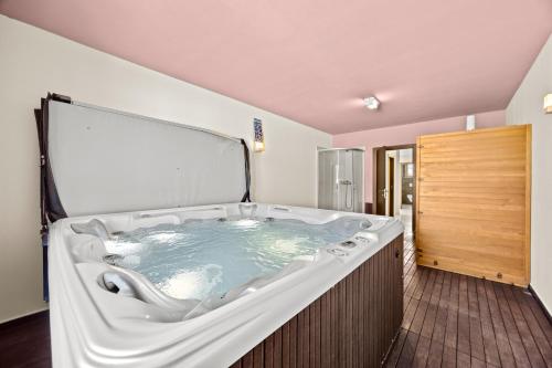 a large bath tub in a room with a wooden door at Villa Palatium for 14 people in Fazana with sauna & jacuzzi only 800 meters from the beach in Valbandon