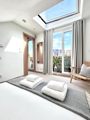 a bedroom with two beds and a skylight at Stunning Central London flat 1 min Bond Street in London