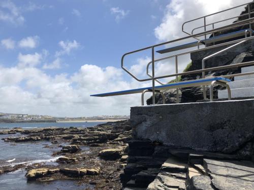 - un bâtiment sur une plage rocheuse avec l'océan dans l'établissement Holiday Home Kilkee HH - GF - - S5 - TR1 Type B - No 907 by Interhome, à Kilkee
