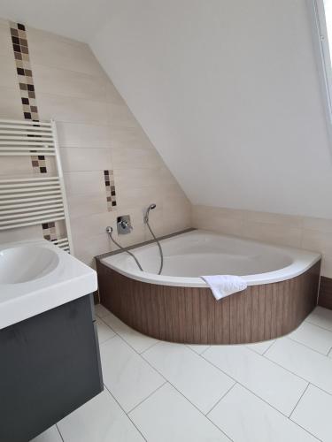 a bathroom with a large tub and a sink at Moritz Apartments - Pfarrgasse 09 in Küllstedt