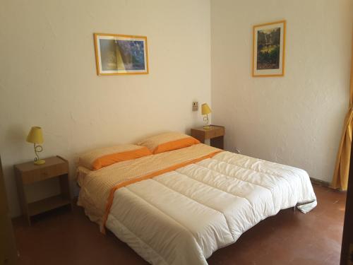 una camera con un letto con due comodini e due lampade di Villa California ad Agnone Bagni