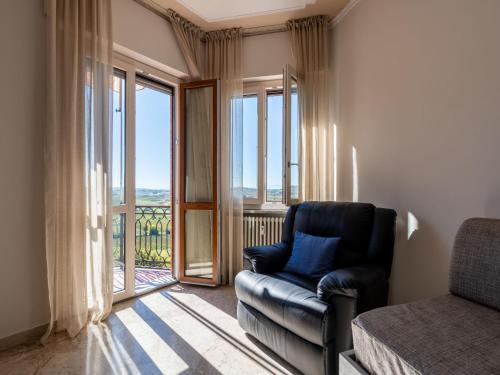 sala de estar con silla de cuero y balcón en Apartment Casa Riggi by Interhome, en Agliano Terme