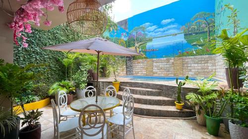 een patio met een tafel met een parasol en een aantal planten bij O Plácido Arte Hostel in Belém