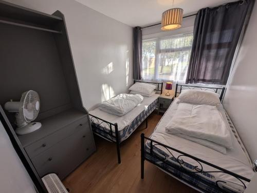 a bedroom with two beds and a window at 194, Belle Aire, Hemsby - Two bed recently renovated chalet, sleeps 4, pet friendly, free Wi-Fi and bed linen and towels included in Hemsby