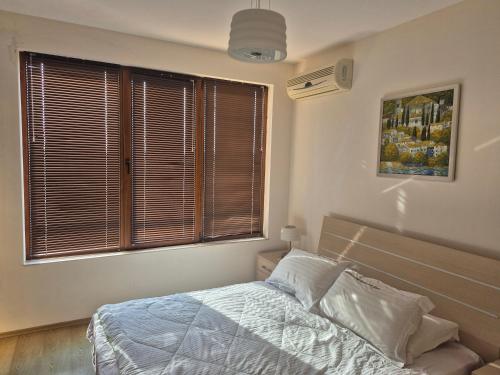 ein Schlafzimmer mit einem Bett und einem großen Fenster in der Unterkunft New Light house golf apartment in Baltschik