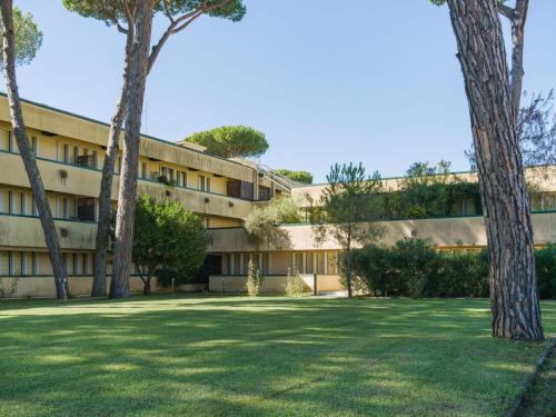 an apartment building with trees in the foreground at Apartment Appartamento Residence Henderson by Interhome in Cinquale