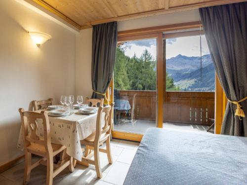 a dining room with a table and a large window at Apartment Residence gli Scoiattoli-2 by Interhome in Madesimo