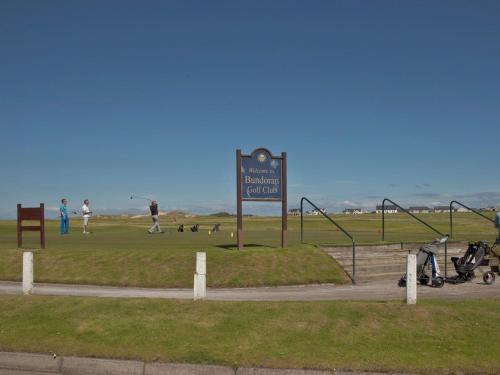 un panneau dans un parc avec des gens jouant dans l'herbe dans l'établissement Holiday Home Seacrest - TR4 HH No 6 - 3 Bed by Interhome, à Bundoran