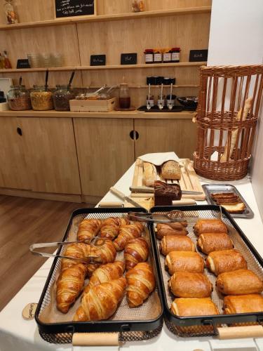 ル・ピュイ・アン・ヴレにあるHôtel Bristol, Le Puy-en-Velayのクロワッサンやその他のペストリーのトレイが置かれたテーブル