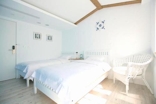 a white bedroom with a large bed and a table at York Hotel in Taipei