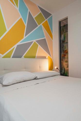 een slaapkamer met een bed met een geometrische muur bij Il Nido dei Cigni in Desenzano del Garda