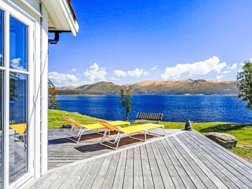 een veranda met stoelen en uitzicht op het water bij Holiday Home Holmen by Interhome in Bakka