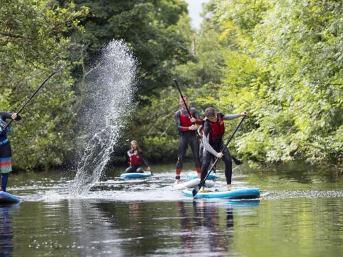 um grupo de pessoas em pranchas de paddle na água em Holiday Home Lakeside HH - FRI - TR1-4Type B No 7 by Interhome em Killaloe