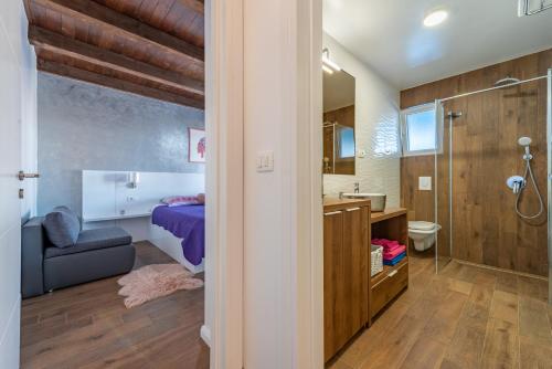 a bathroom with a bed a sink and a shower at Stone villa Jurenda with pool in Debeljak