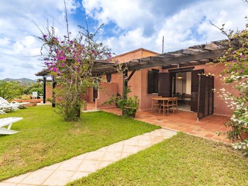 ein Haus mit einem Garten und einer Terrasse in der Unterkunft Holiday Home Villa 19 by Interhome in SantʼAmanza