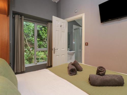 una camera da letto con un letto con asciugamani sopra di 32 Grasmere a Troutbeck Bridge