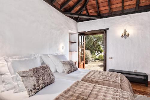 ein Schlafzimmer mit einem großen weißen Bett und Kissen in der Unterkunft Finca El Ingeniero by Huskalia in San Pedro