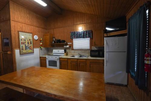 コンカンにあるCypress Villa 5の木製のキャビネットと白い冷蔵庫を備えたキッチン