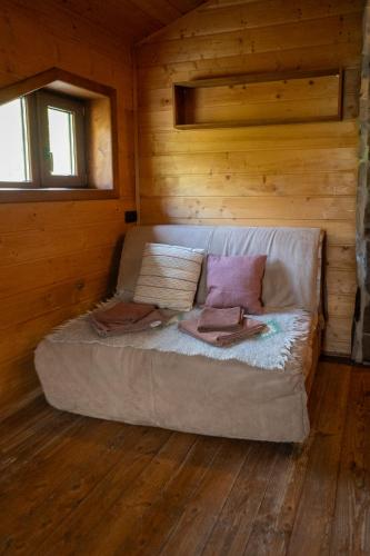 a bed in a log cabin with two pillows at Camp Bilyi Slon in Dzembronya