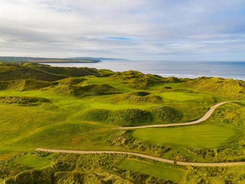 an aerial view of a golf course with a road leading up to a mountain at Holiday Home Ballybunion - TR4 HC No 27 by Interhome in Ballybunion