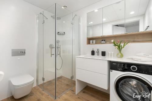 a bathroom with a washing machine and a shower at Pinea Prestige 213 - basen, sauna, jacuzzi w cenie pobytu - widok na morze - Easy - Rent Apartments in Pobierowo