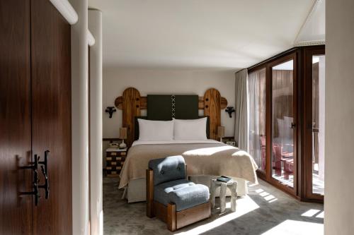 a bedroom with a bed and a blue chair at Experimental Chalet Val d'Isère in Val-d'Isère