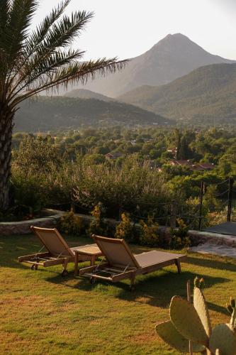 two lounge chairs and a table with a view of a mountain at Kassandra Heritage in Oludeniz