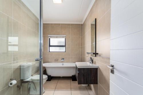 Un baño con bañera, inodoro y lavabo. en The Sandown 178 by CTHA, en Parklands