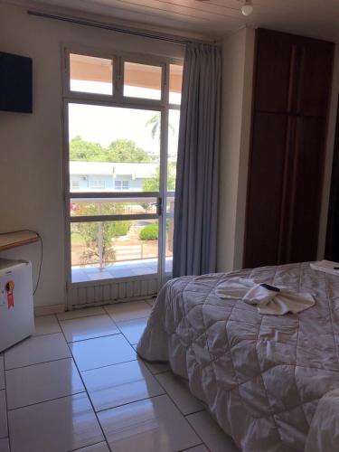 a bedroom with a bed and a large window at Vyalle Hotel in Machadinho
