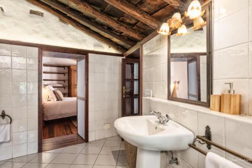 ein Badezimmer mit Waschbecken und Spiegel und ein Schlafzimmer in der Unterkunft Finca El Ingeniero by Huskalia in San Pedro