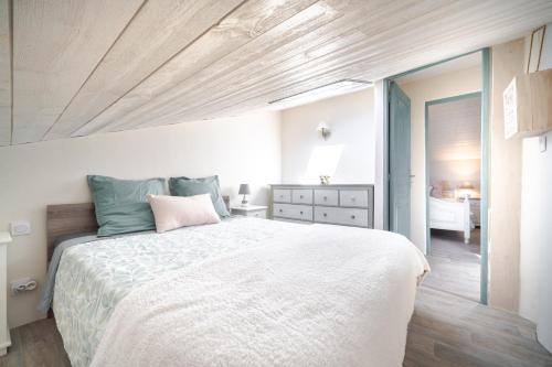 a bedroom with a large white bed and a bathroom at Le Baiser du Soleil - Piscine Privée in Mirabel-aux-Baronnies