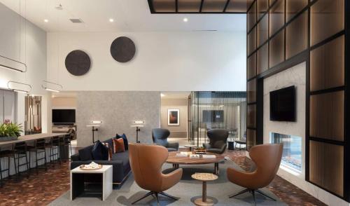 a living room with a couch and a table and chairs at Hyatus Luxury Residences Boston South Bay Designer Collection in Boston