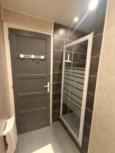a bathroom with a door and a mirror at La parenthèse ardéchoise in Le Pouzin