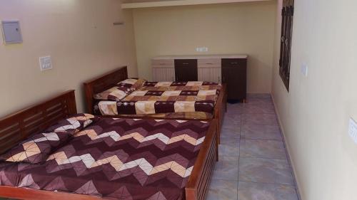 a bedroom with two beds in a room at Jayanthi home stay in Tiruvannāmalai